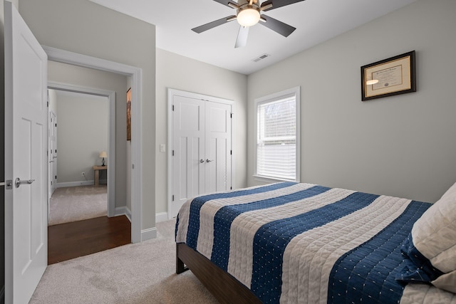 bedroom featuring visible vents, baseboards, ceiling fan, carpet flooring, and a closet