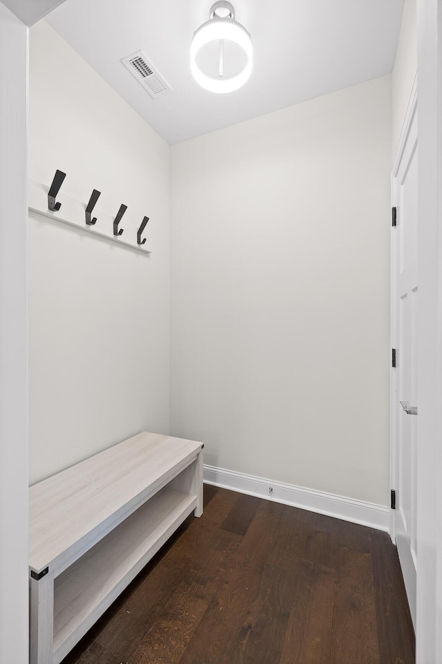 mudroom featuring visible vents, baseboards, and dark wood-type flooring