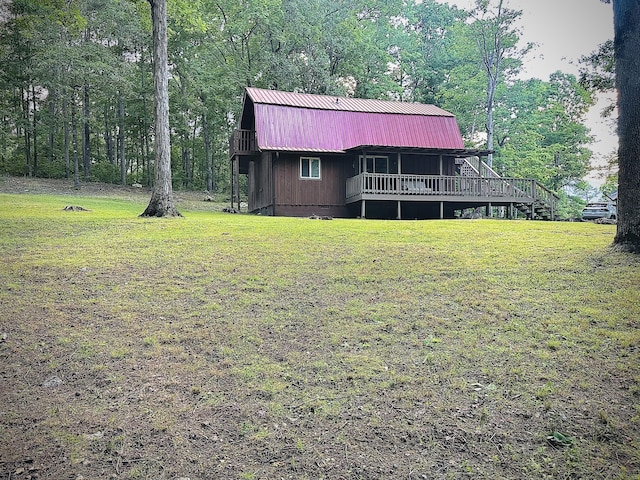 142 Huckleberry Trl, Lafayette, GA 30728 - view of front of home featuring a front lawn, metal roof, a gambrel roof, a deck, and a view of trees