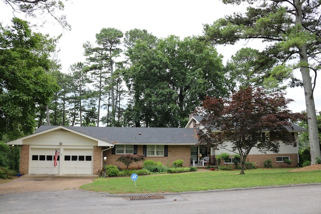 view of front facade featuring brick siding, a front lawn, concrete driveway, and an attached garage