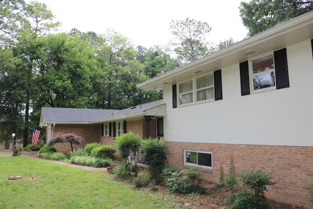 view of front of property featuring brick siding and a front lawn