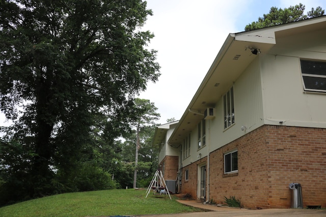 view of property exterior featuring brick siding and a lawn