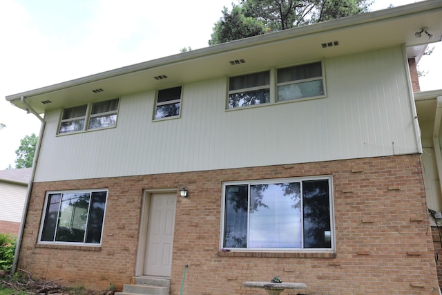 view of front facade with entry steps and brick siding