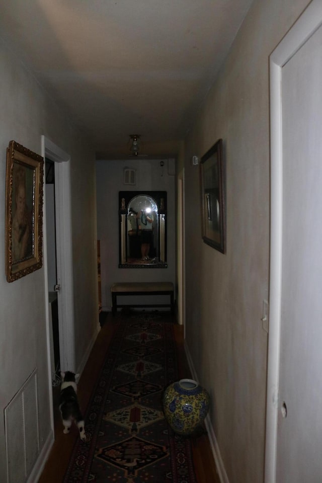 hallway featuring baseboards and visible vents