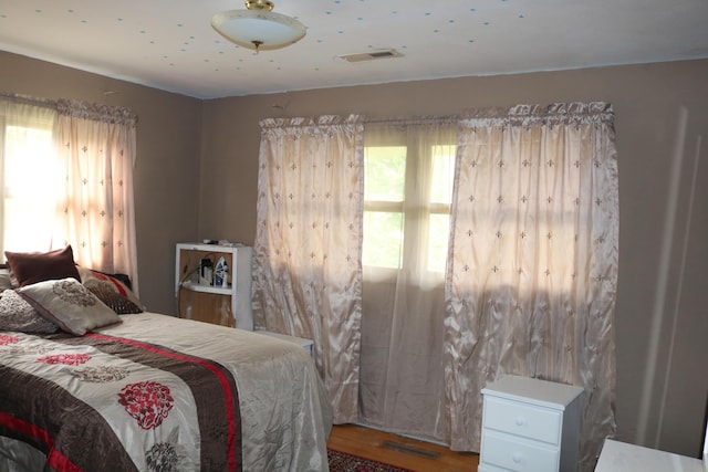 bedroom with visible vents and wood finished floors