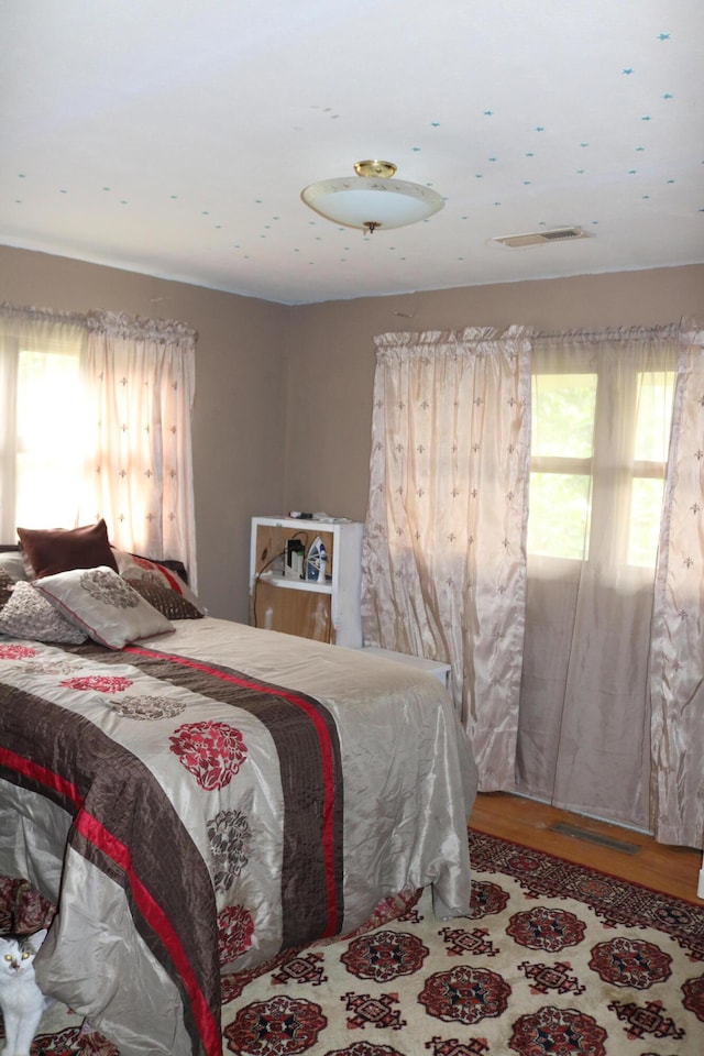 bedroom with wood finished floors and visible vents