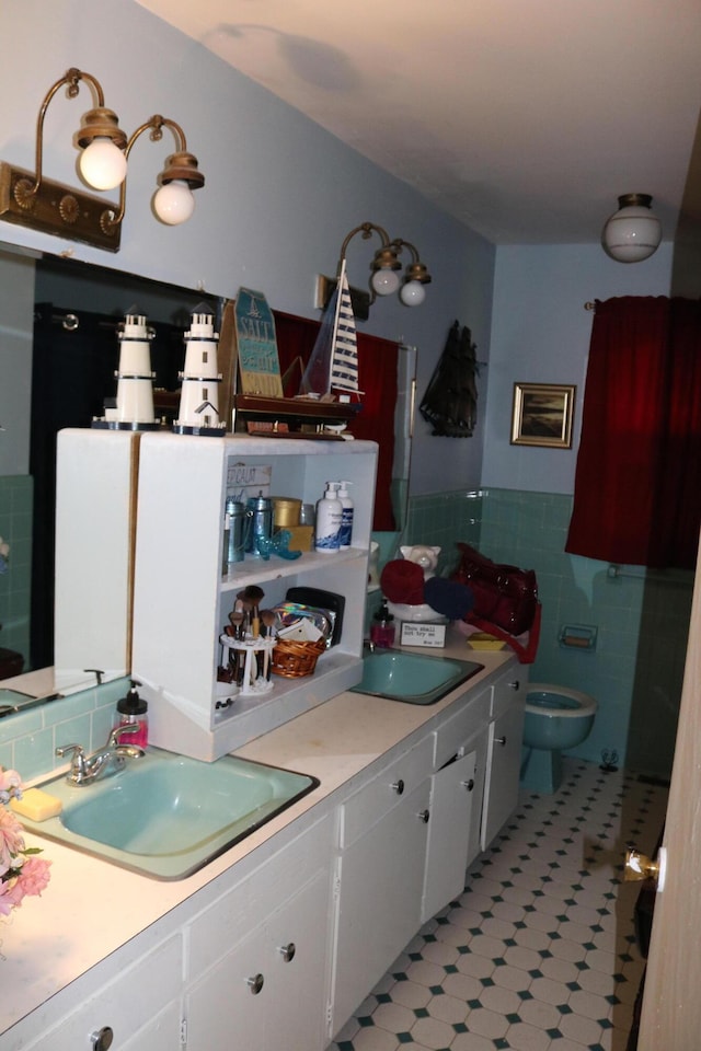 kitchen with a sink, white cabinetry, tile walls, light countertops, and light floors