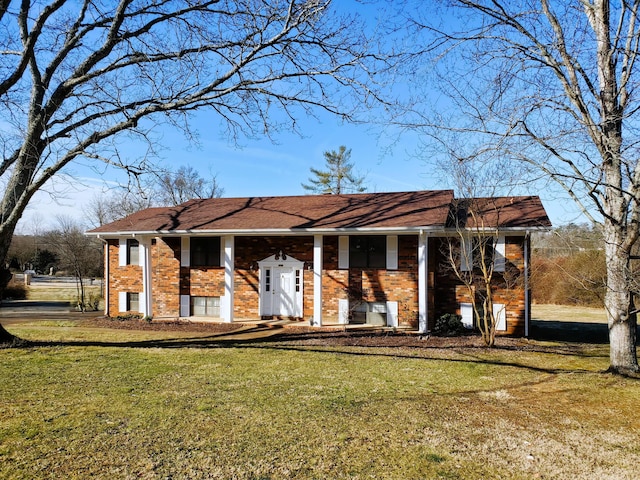 split foyer home with brick siding and a front lawn