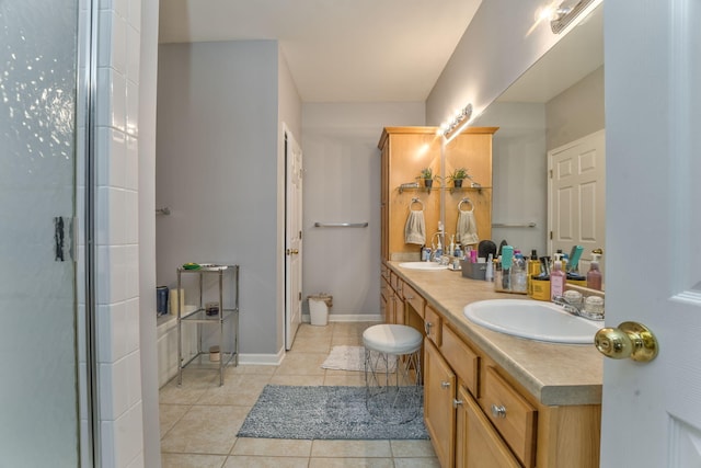 bathroom featuring tile patterned flooring, double vanity, baseboards, and a sink