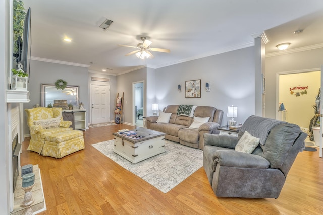 living room with visible vents, crown molding, baseboards, ceiling fan, and wood finished floors