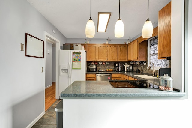 kitchen with a sink, backsplash, stainless steel dishwasher, white refrigerator with ice dispenser, and a peninsula