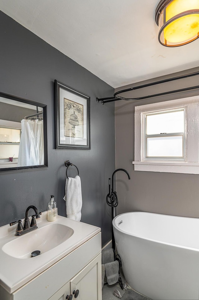 full bathroom featuring a soaking tub and vanity