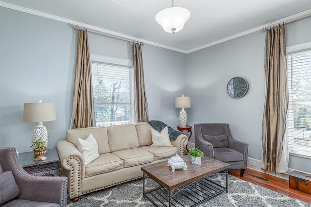 living room featuring visible vents, crown molding, baseboards, and wood finished floors