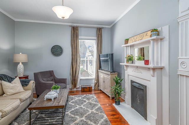 living area with a fireplace with flush hearth, wood finished floors, and ornamental molding