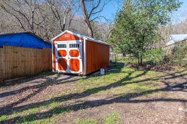 view of shed featuring fence