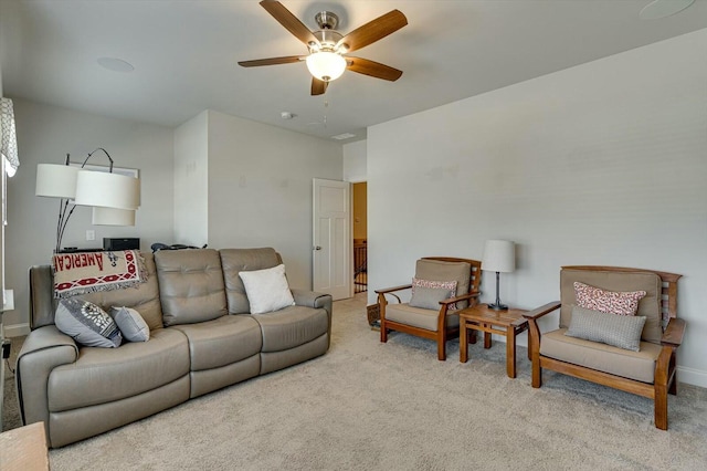 carpeted living room featuring baseboards and ceiling fan