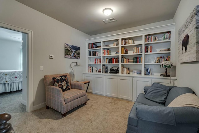 sitting room featuring visible vents and light carpet