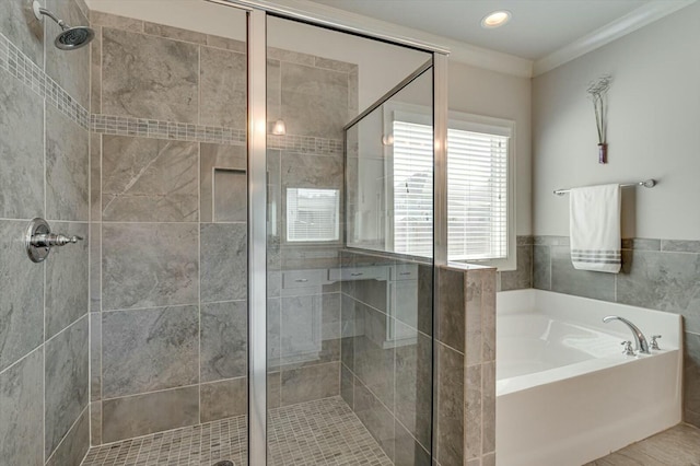 bathroom featuring a stall shower, a garden tub, and ornamental molding