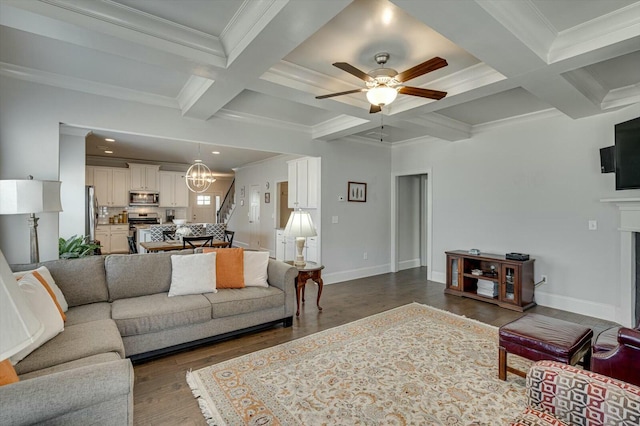 living area featuring beamed ceiling, ceiling fan with notable chandelier, coffered ceiling, wood finished floors, and crown molding