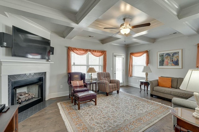 living room with a wealth of natural light, visible vents, baseboards, and ceiling fan