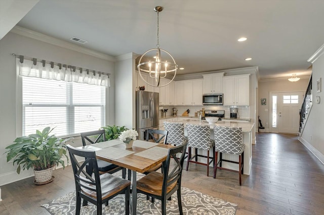 dining room featuring dark wood-style floors, visible vents, a chandelier, and crown molding