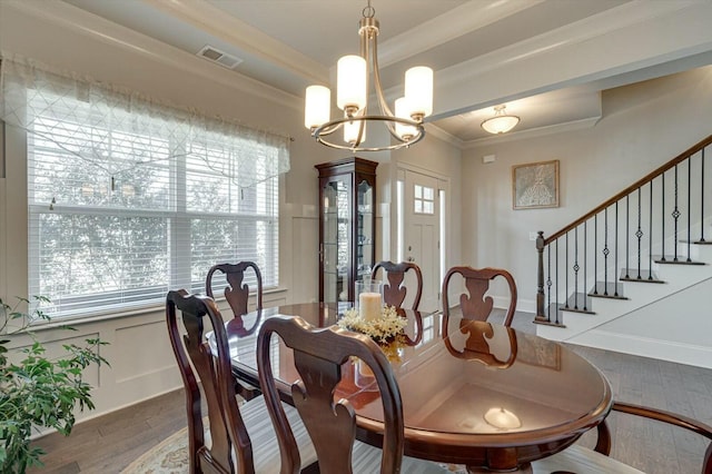 dining area with an inviting chandelier, crown molding, a healthy amount of sunlight, and visible vents