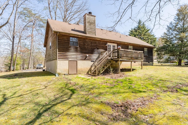 rear view of house featuring stairs, a wooden deck, a yard, and a chimney