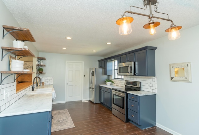 kitchen featuring wood finish floors, blue cabinets, open shelves, backsplash, and appliances with stainless steel finishes