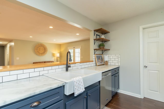 kitchen with a sink, blue cabinetry, open shelves, decorative backsplash, and dishwasher