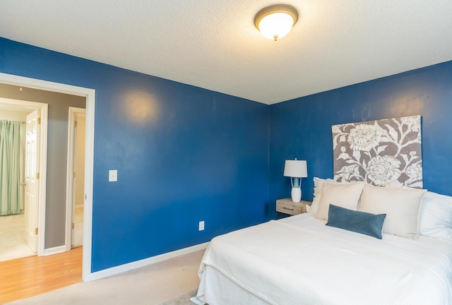 bedroom featuring a textured ceiling and baseboards