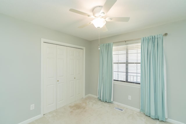 unfurnished bedroom with visible vents, baseboards, carpet floors, a closet, and a ceiling fan