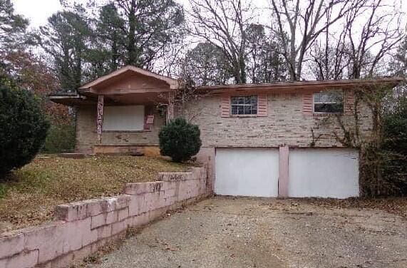 ranch-style home featuring a garage and driveway