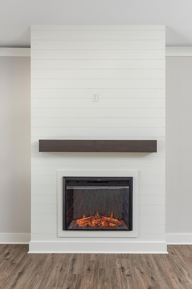 room details with a fireplace, baseboards, and wood finished floors
