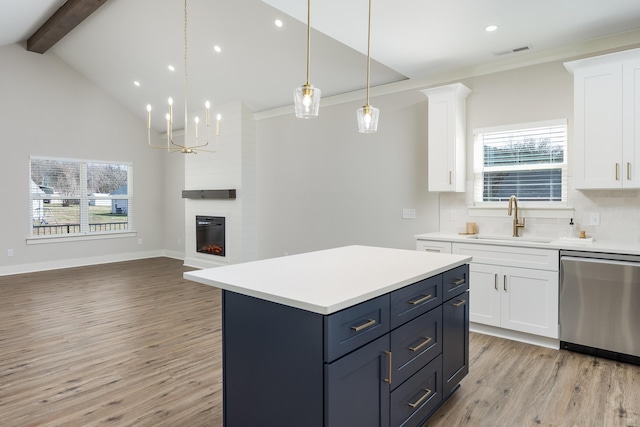 kitchen with light wood finished floors, visible vents, a large fireplace, dishwasher, and a sink