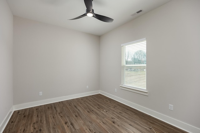 spare room featuring visible vents, dark wood-style floors, baseboards, and ceiling fan