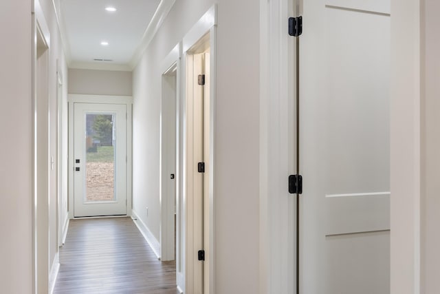 corridor featuring recessed lighting, baseboards, wood finished floors, and ornamental molding