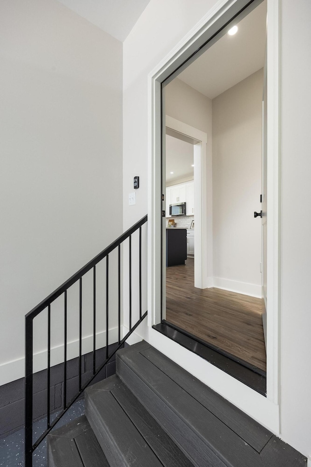 staircase featuring wood finished floors, recessed lighting, and baseboards