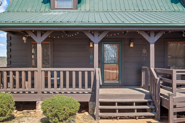 entrance to property with a porch and metal roof