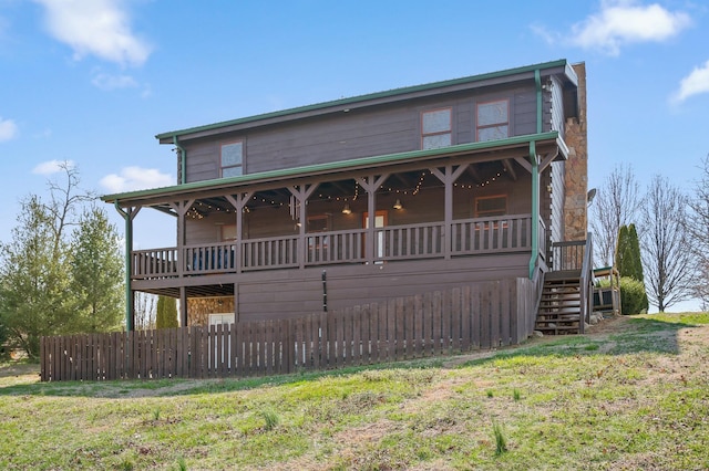 view of front of property featuring a front lawn, stairway, and fence