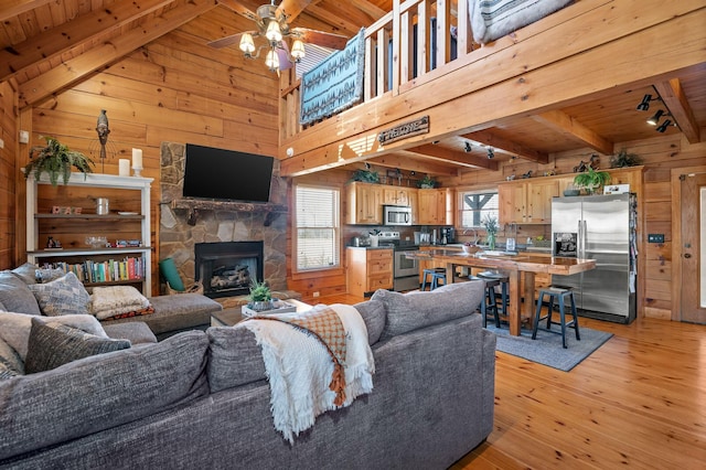 living room with wooden walls, wood ceiling, beamed ceiling, and a wealth of natural light