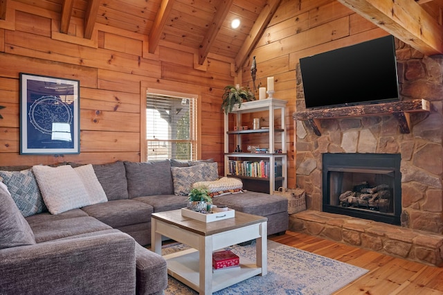 living area with hardwood / wood-style floors, lofted ceiling with beams, a fireplace, wood ceiling, and wood walls