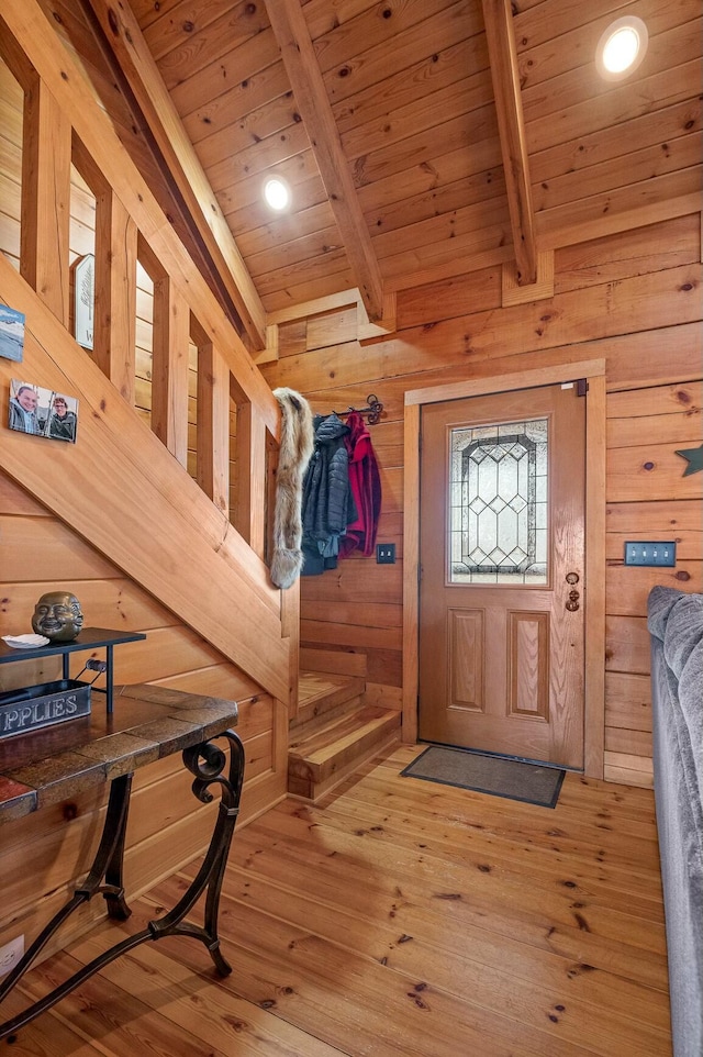 entryway with wooden ceiling, wooden walls, beamed ceiling, and wood-type flooring