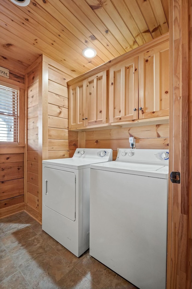 washroom featuring cabinet space, wood ceiling, separate washer and dryer, and wood walls