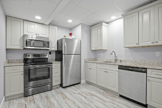 kitchen featuring light wood finished floors, recessed lighting, white cabinets, stainless steel appliances, and a sink