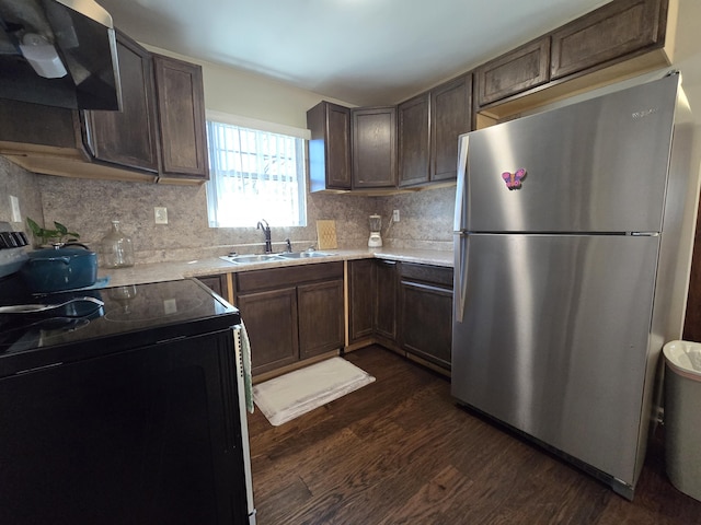 kitchen featuring ventilation hood, dark wood-style flooring, freestanding refrigerator, a sink, and black electric range oven