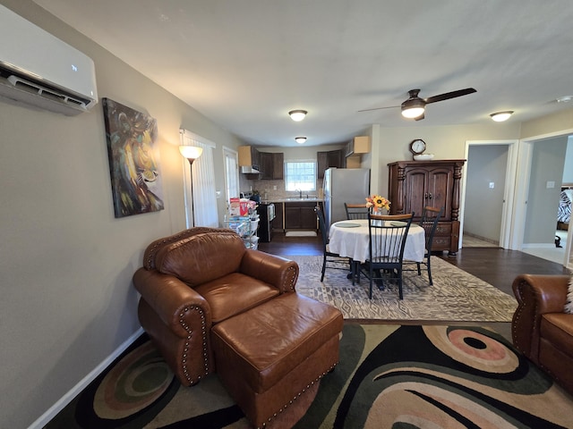 living room with baseboards, a ceiling fan, an AC wall unit, and dark wood-style flooring