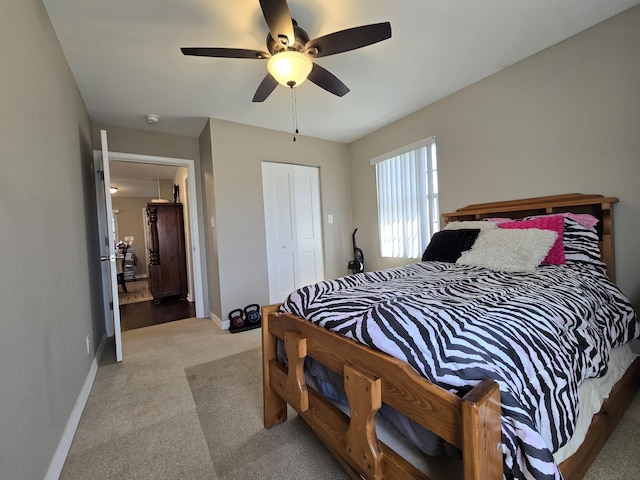 carpeted bedroom with a closet, baseboards, and a ceiling fan