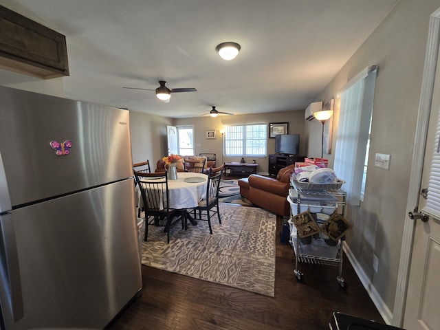 living area featuring dark wood finished floors, baseboards, and a wall mounted AC