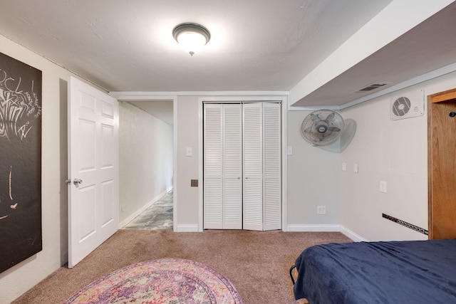 carpeted bedroom featuring visible vents, baseboards, and a closet
