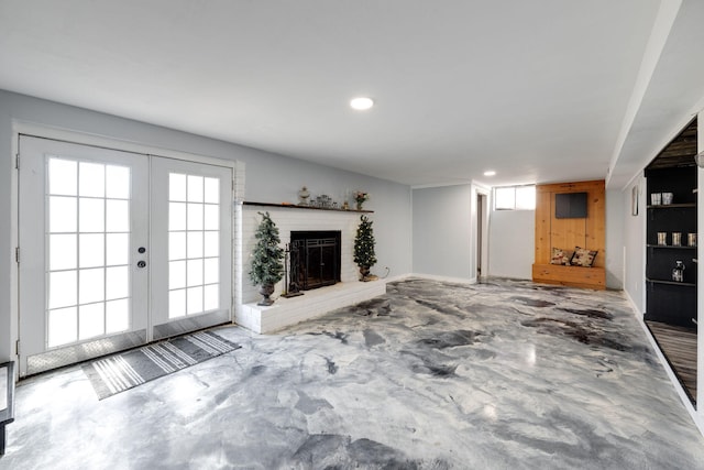 unfurnished living room featuring recessed lighting, french doors, concrete flooring, and a fireplace